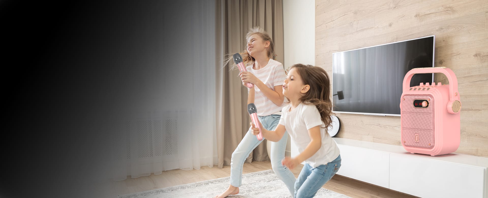 Two girls are singing with JYX TX02 karaoke machine in pink wih two wireless microphones