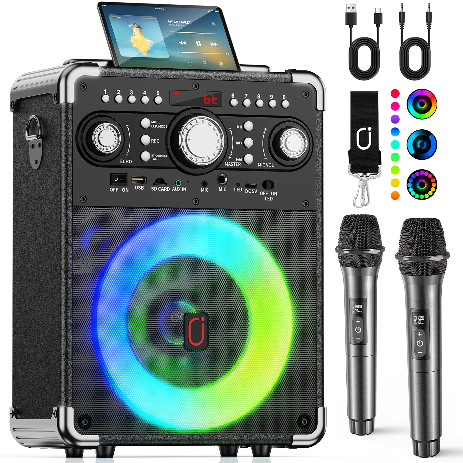 Front view of the JYX S8 Bluetooth karaoke speaker with a tablet playing music, two wireless microphones, connection cables, and colorful LED lighting.