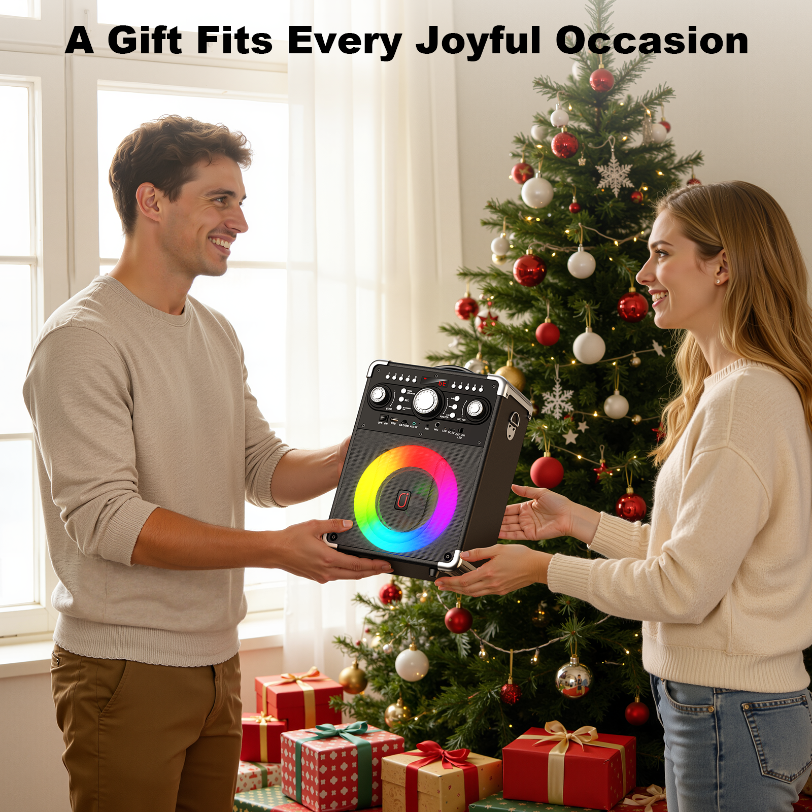 A smiling couple exchanging a JYX S8 karaoke speaker as a Christmas gift beside a decorated Christmas tree and wrapped presents.